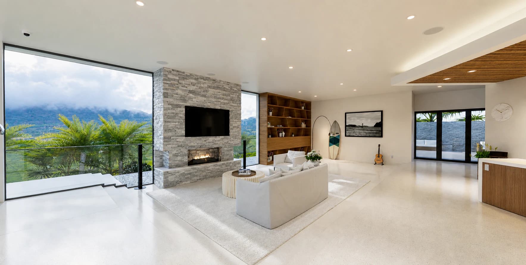 Virtual oceanfront living room with a stone fireplace, built-in shelving, and surfboards.
