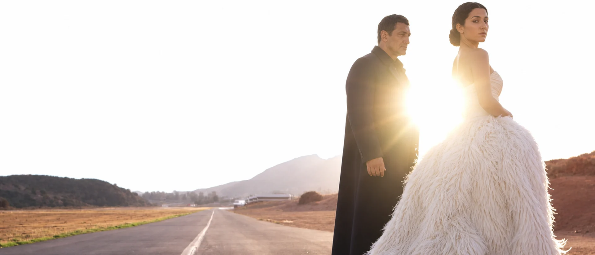 Cleopatra and Mark Antony recast in a backlit contemporary desert fashion film frame.